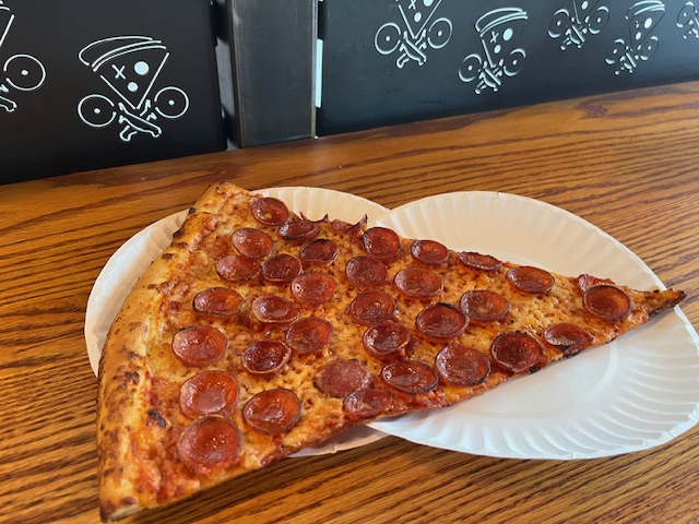 28 inch pizza in Charlotte a slice sits on two paper plates